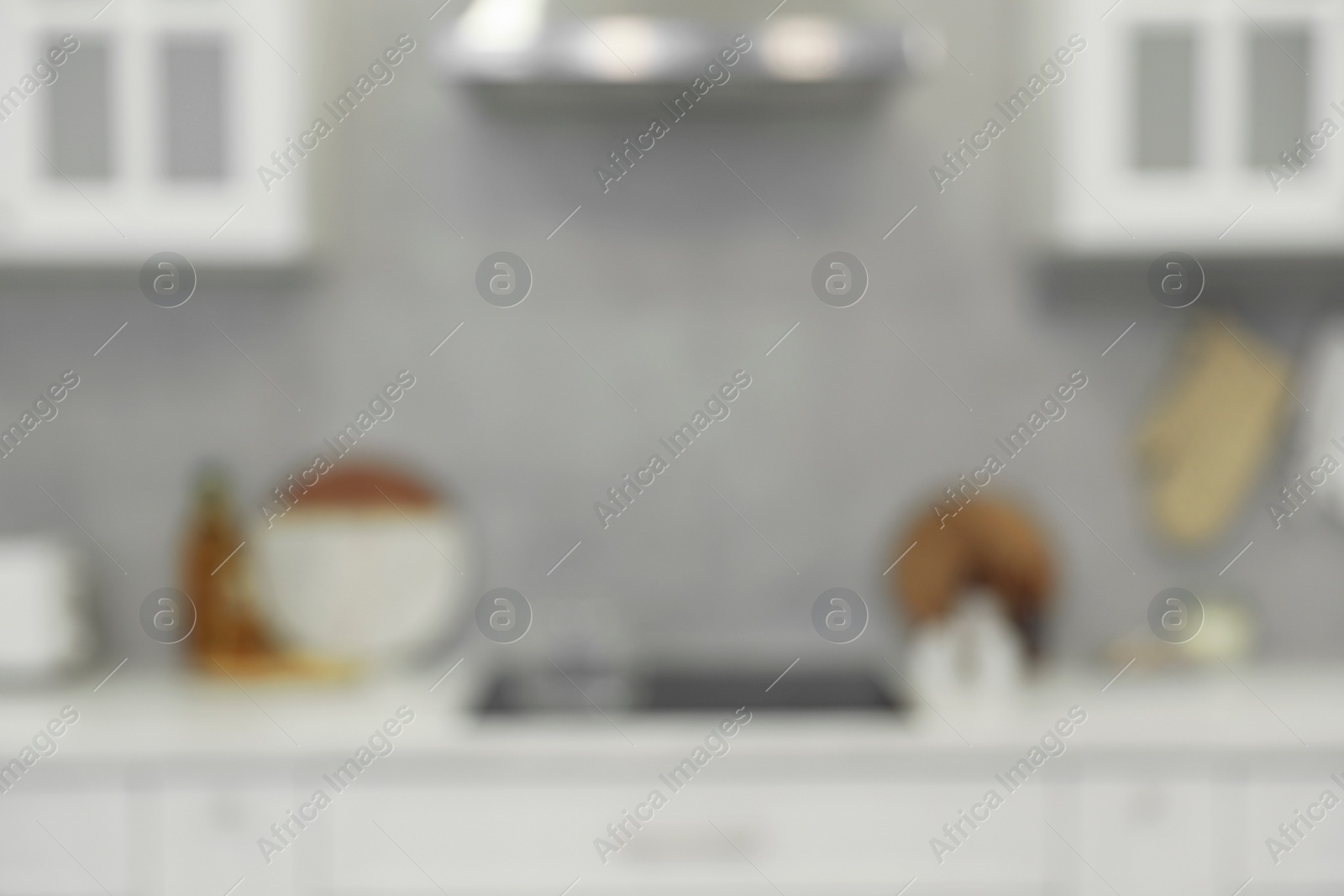 Photo of White stylish kitchen with furniture, blurred view. Interior design