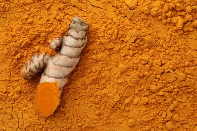 Cut raw root on aromatic turmeric powder, top view. Space for text