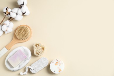 Photo of Bath accessories. Flat lay composition with personal care products and cotton flowers on beige background, space for text