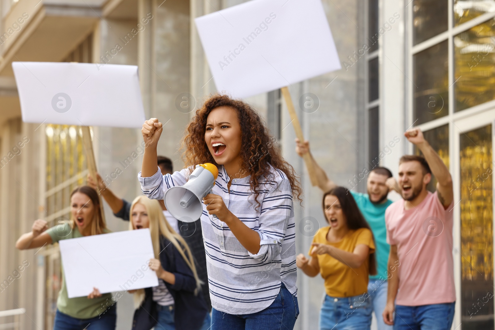 Image of Emotional African American young woman with megaphone at protest outdoors