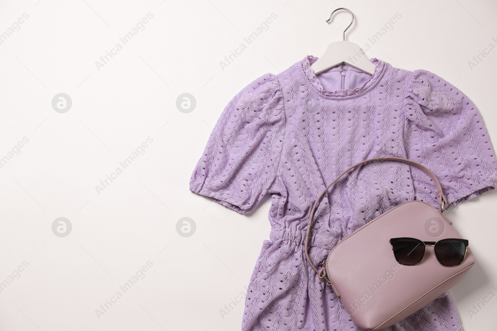 Photo of Stylish outfit with beautiful dress on white background, top view. Rental clothing service