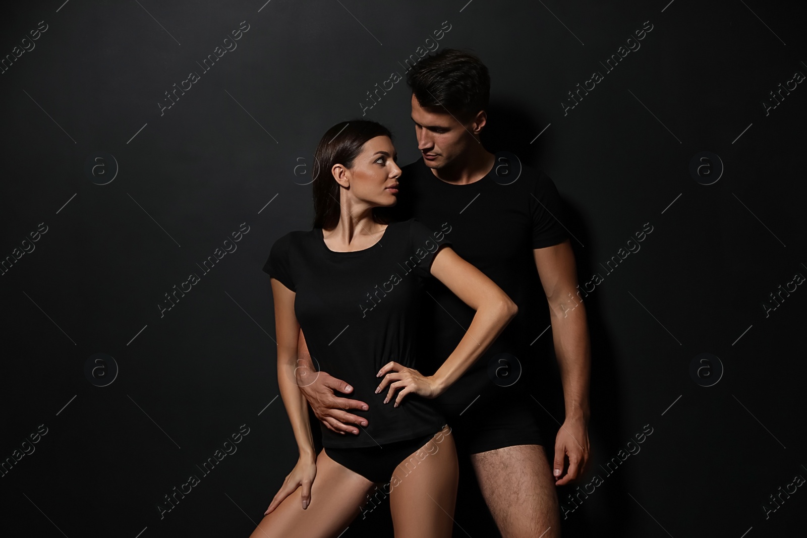 Image of Young couple wearing underwear on black background 