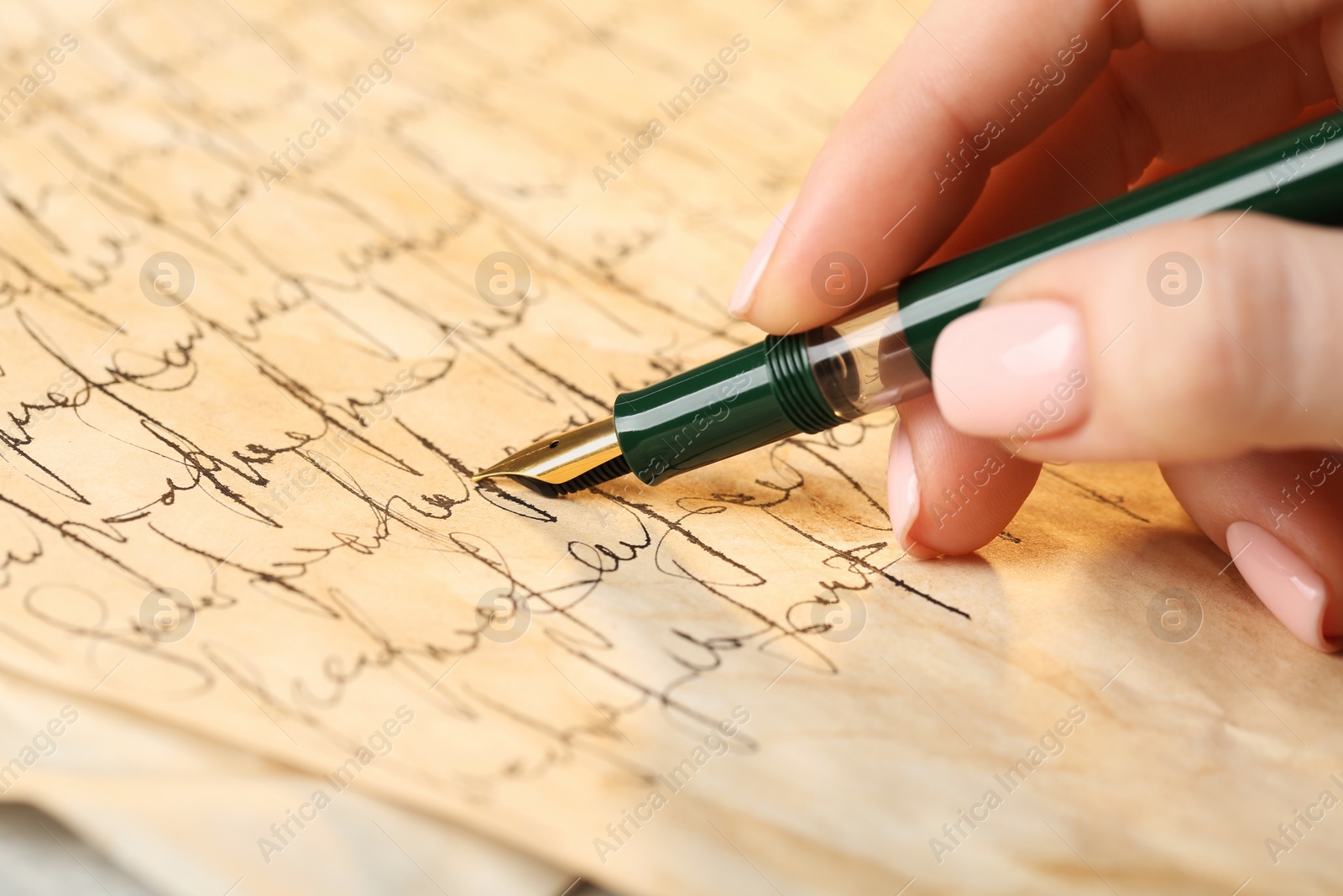 Photo of Woman writing letter with fountain pen, closeup