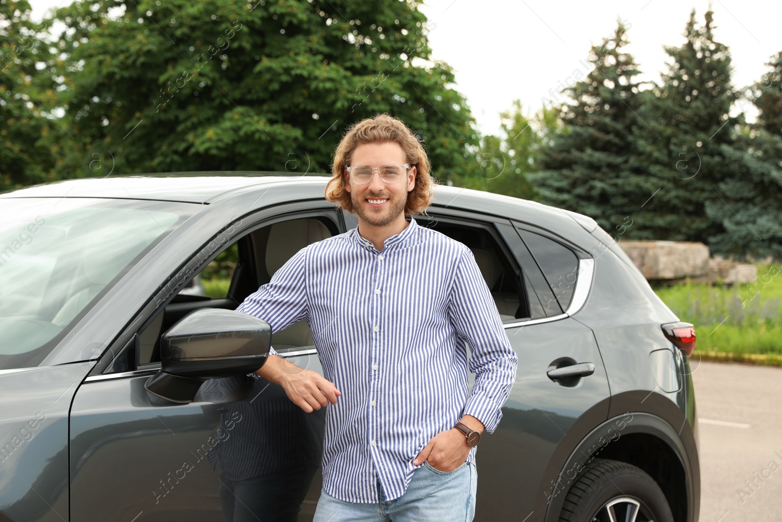 Photo of Attractive young man near luxury car outdoors