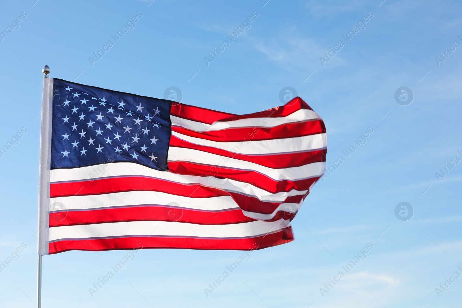 Photo of American flag fluttering outdoors on sunny day