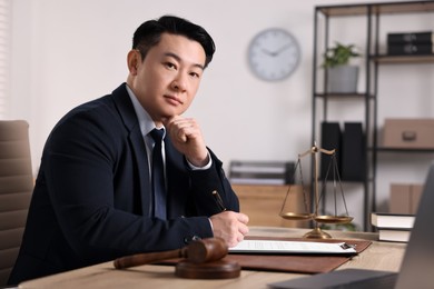 Photo of Notary writing notes at wooden table in office