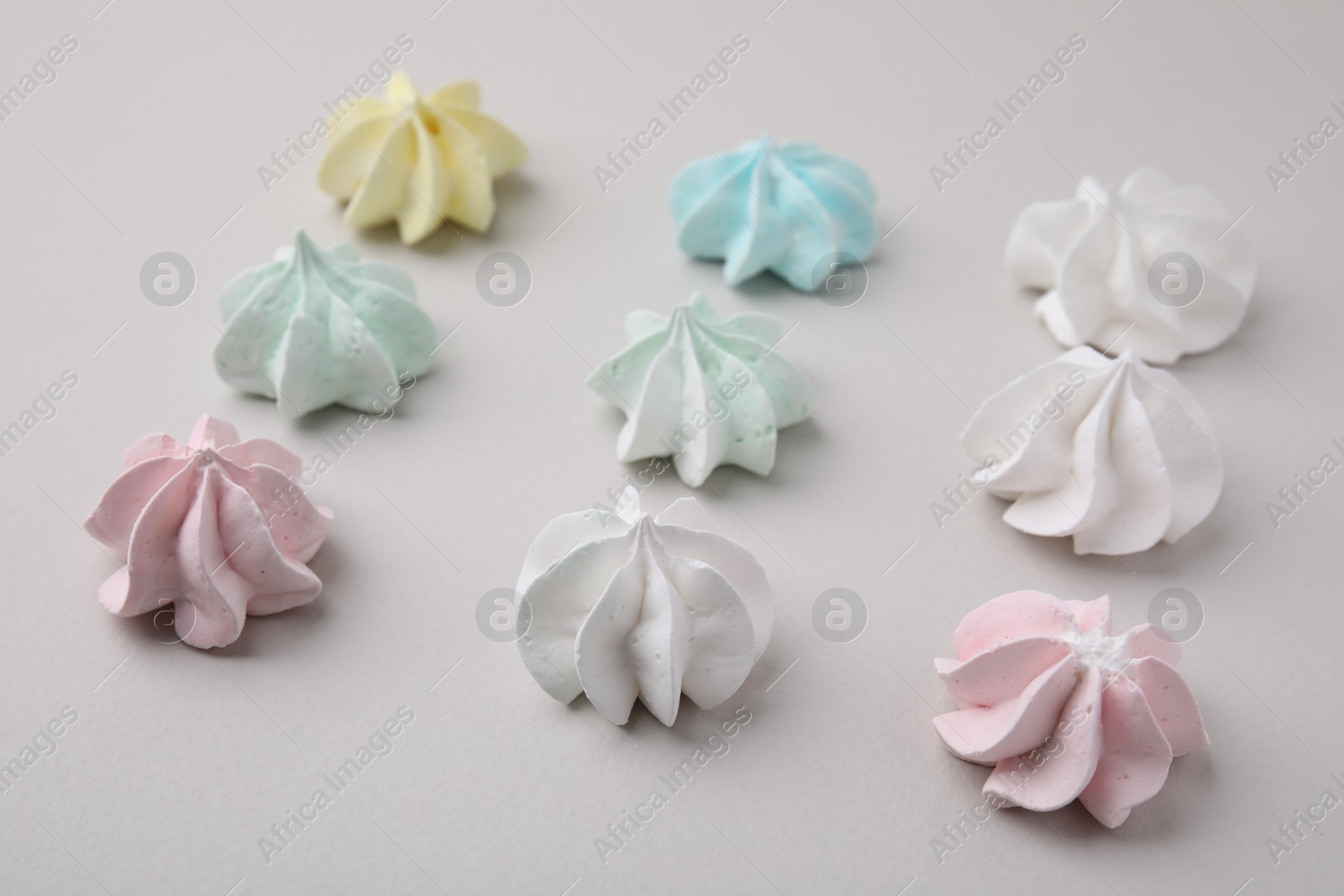 Photo of Delicious meringue cookies on light background, closeup