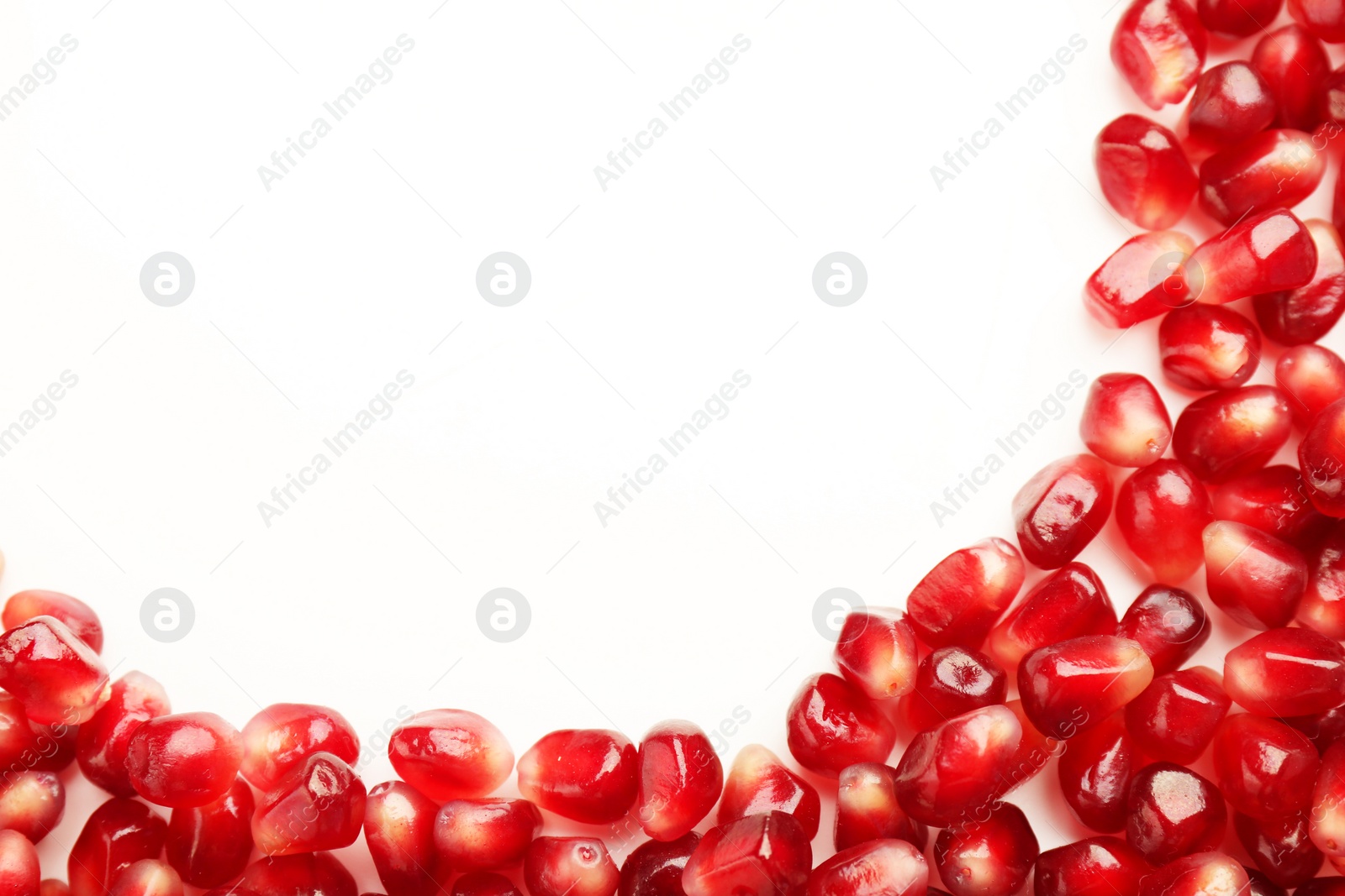 Photo of Many ripe juicy pomegranate grains on white background, flat lay. Space for text