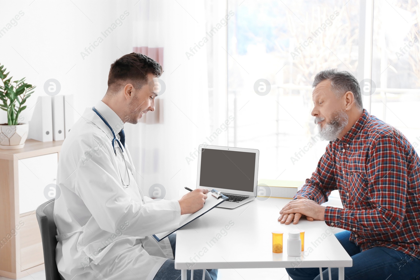 Photo of Male doctor consulting patient in clinic