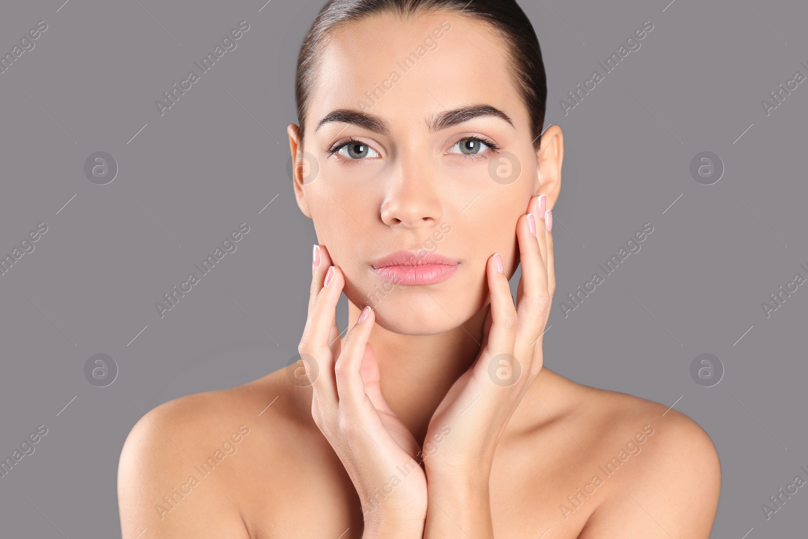 Photo of Portrait of beautiful young woman on grey background. Lips contouring, skin care and cosmetic surgery concept