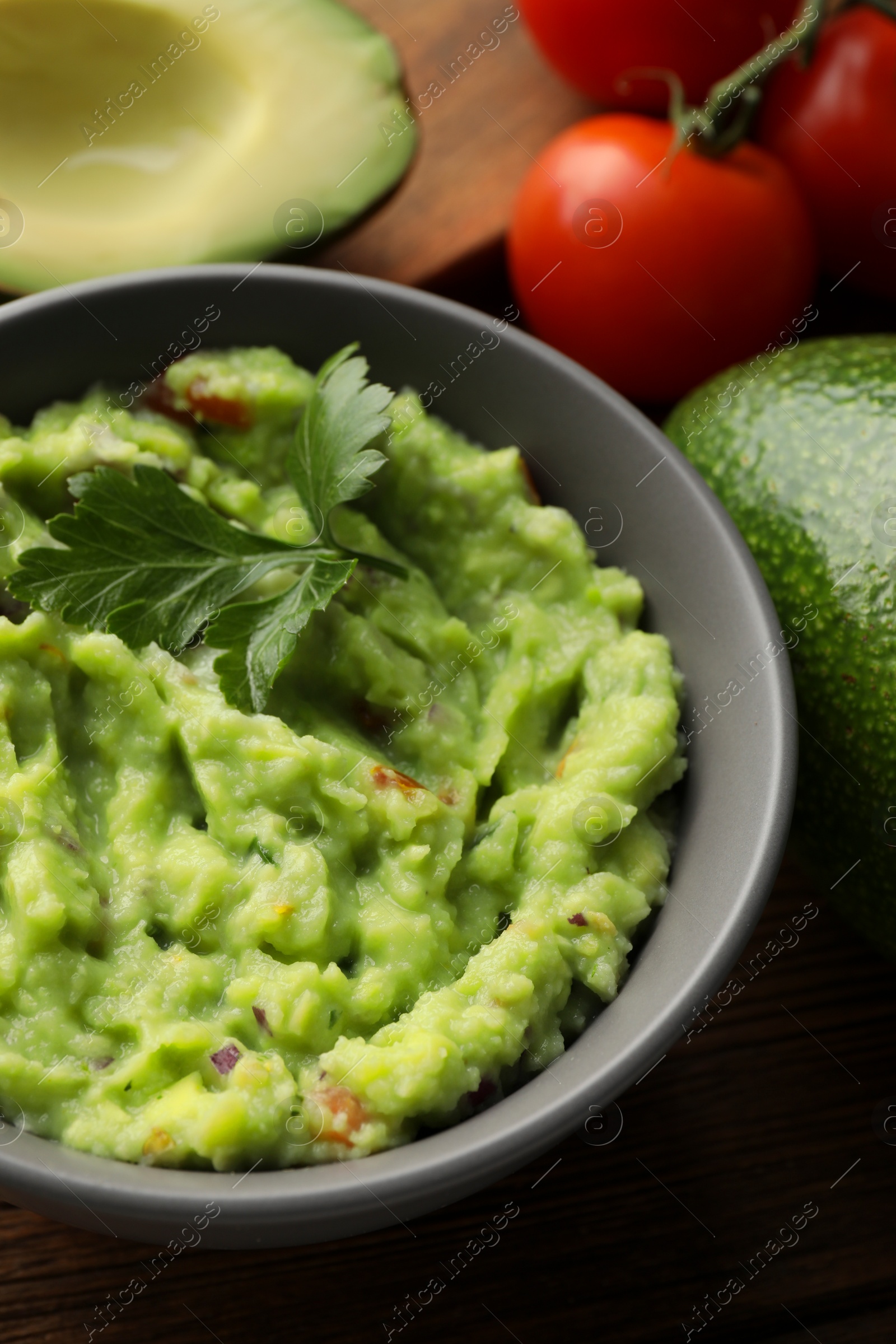 Photo of Delicious guacamole and different ingredients on table, closeup