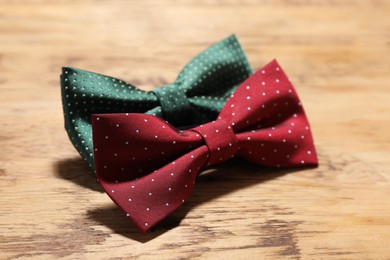 Photo of Different stylish bow ties on wooden table, closeup