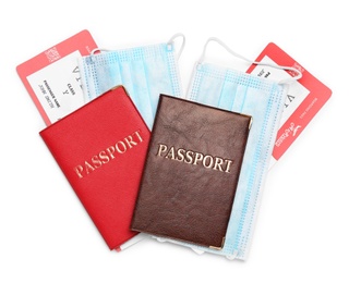 Photo of Passports, tickets and protective mask on white background, top view. Travel during quarantine