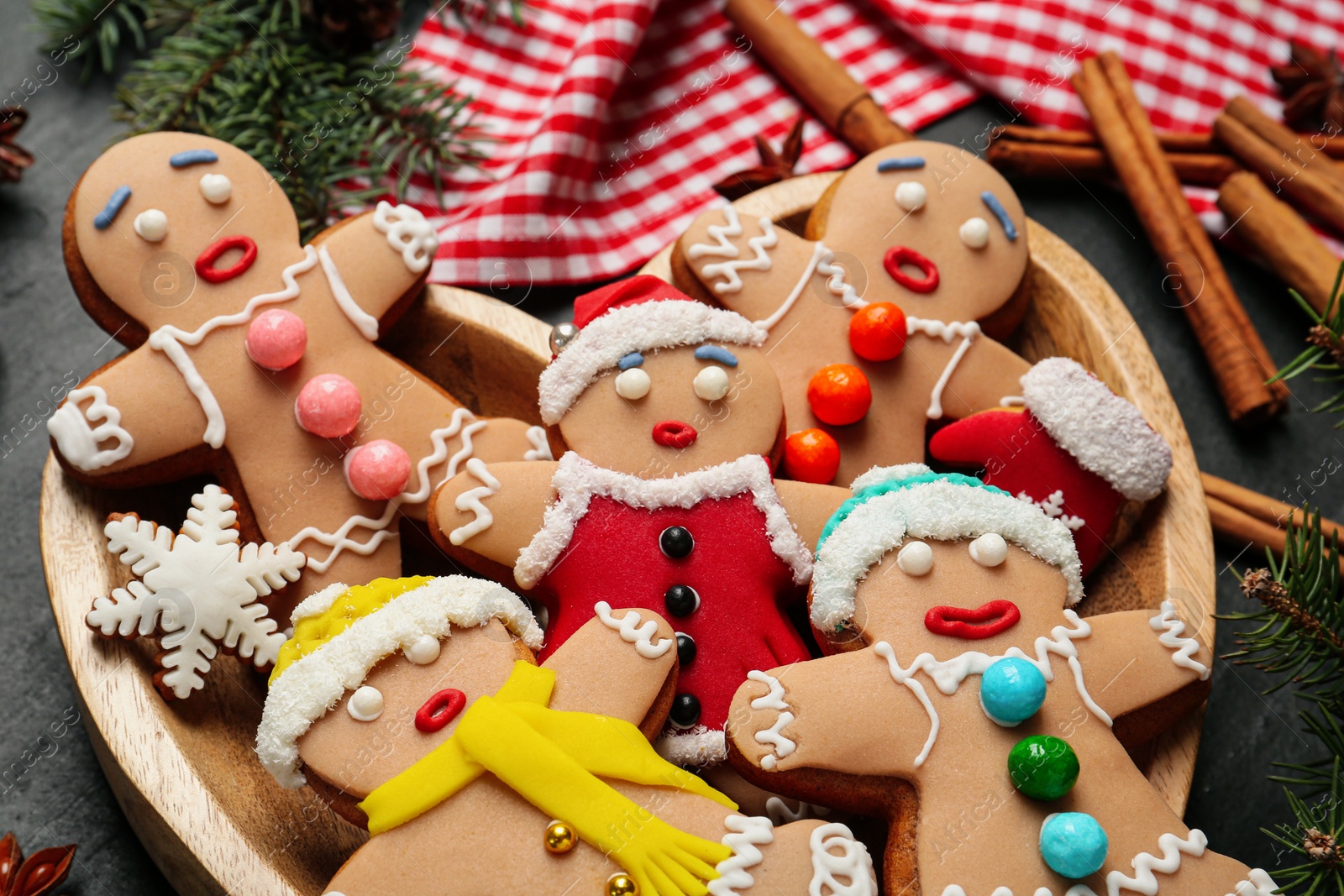 Photo of Delicious Christmas cookies and fir branches on black table, closeup