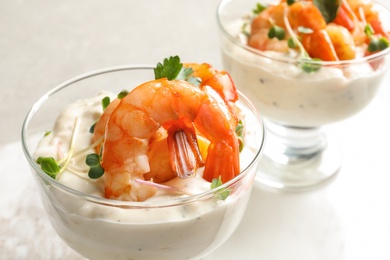 Bowls with fried shrimps and sauce on light background