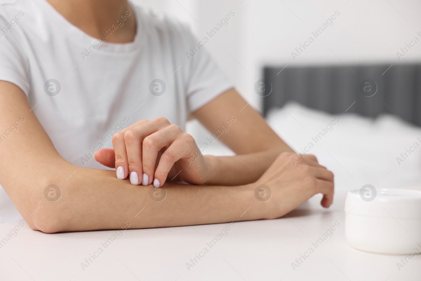 Photo of Woman with dry skin checking her arm indoors, closeup