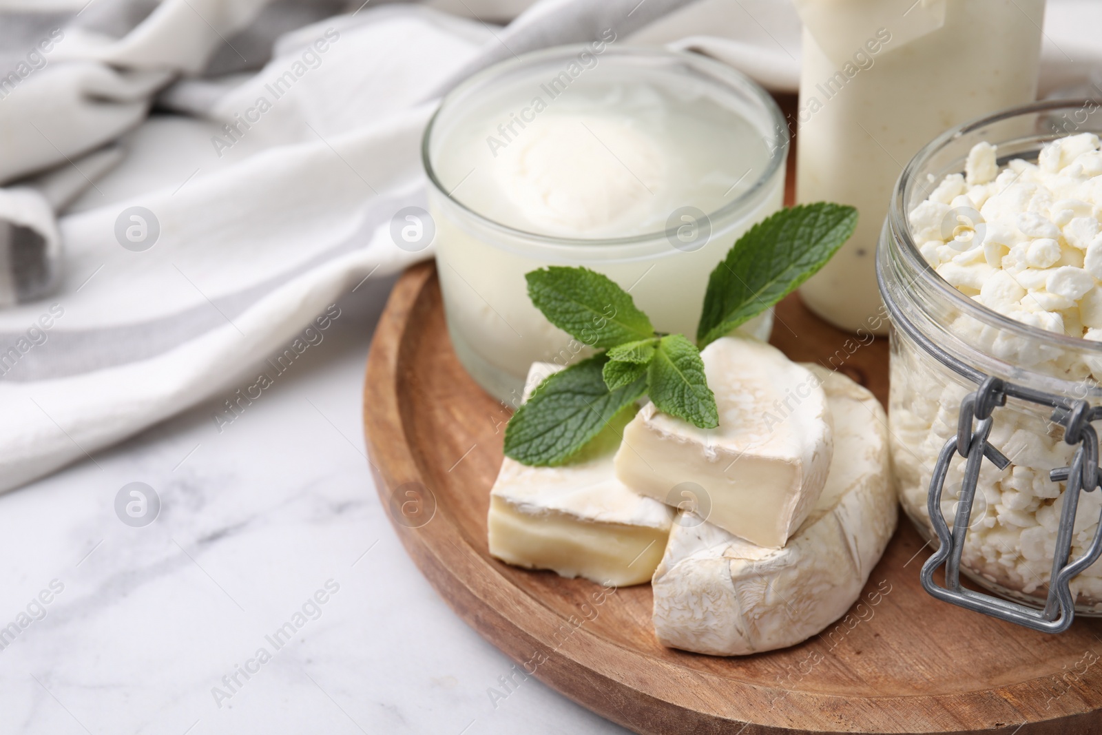 Photo of Different dairy products and mint on white marble table