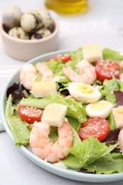 Delicious Caesar salad with shrimps on light table