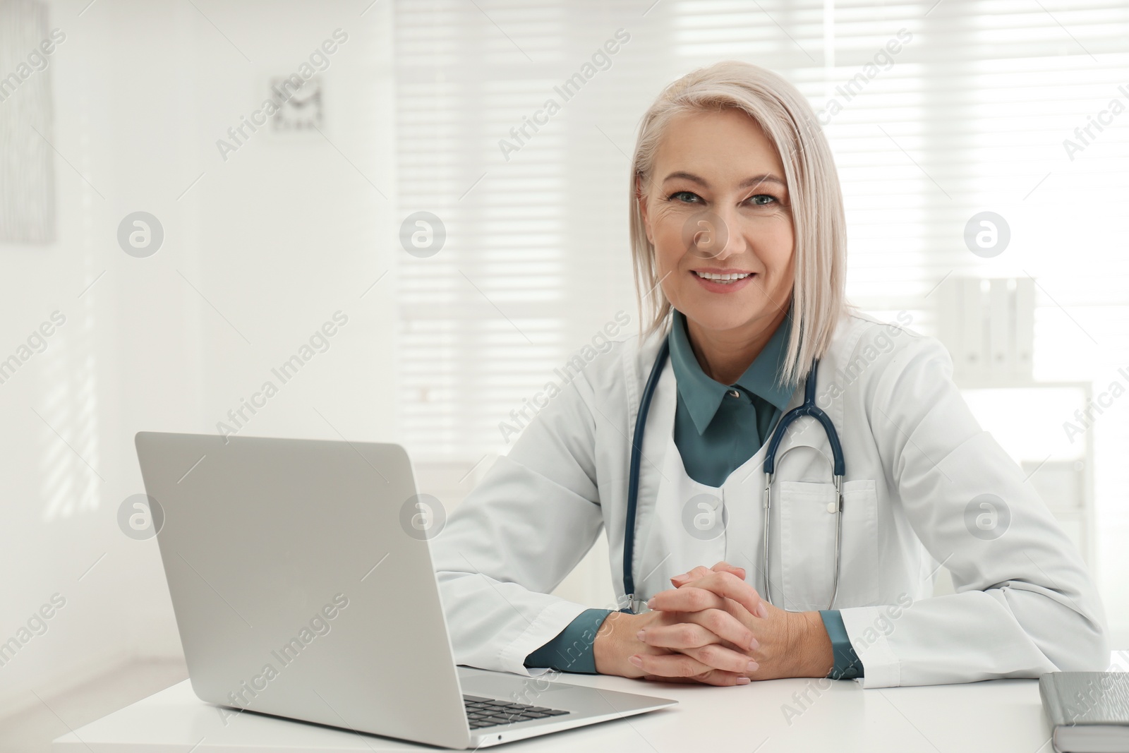 Photo of Portrait of mature female doctor in white coat at workplace