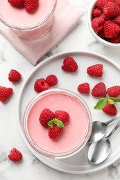 Photo of Delicious raspberry mousse with mint on white marble table, flat lay