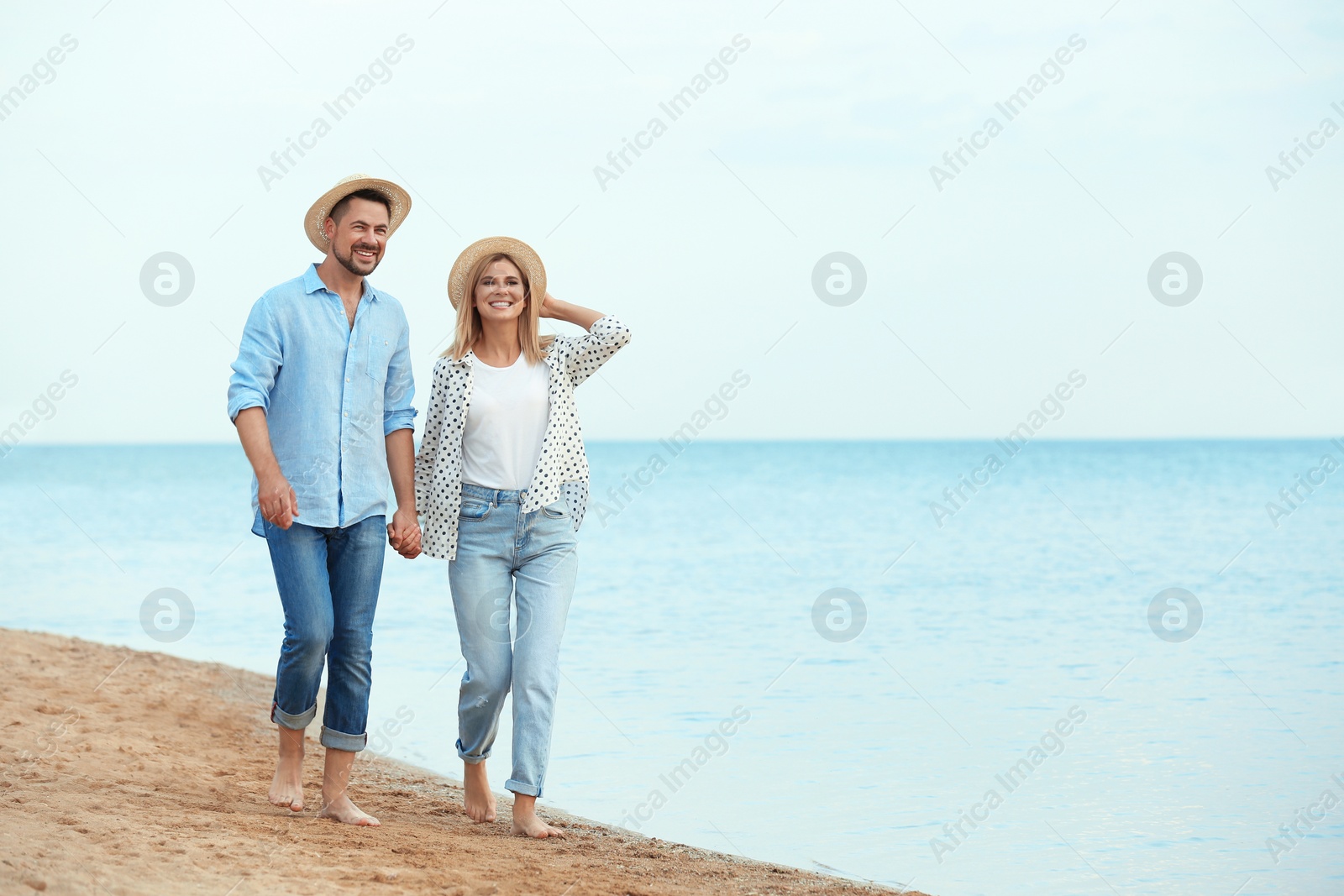 Photo of Happy romantic couple walking on beach, space for text