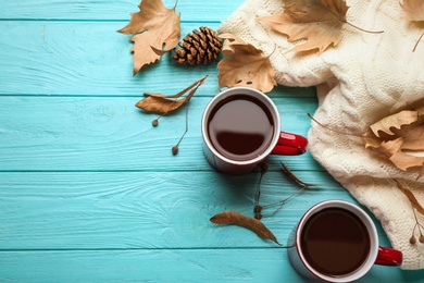 Photo of Flat lay composition with cups of hot drink on blue wooden table, space for text. Cozy autumn atmosphere