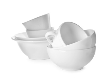 Photo of Clean bowls and cups on white background