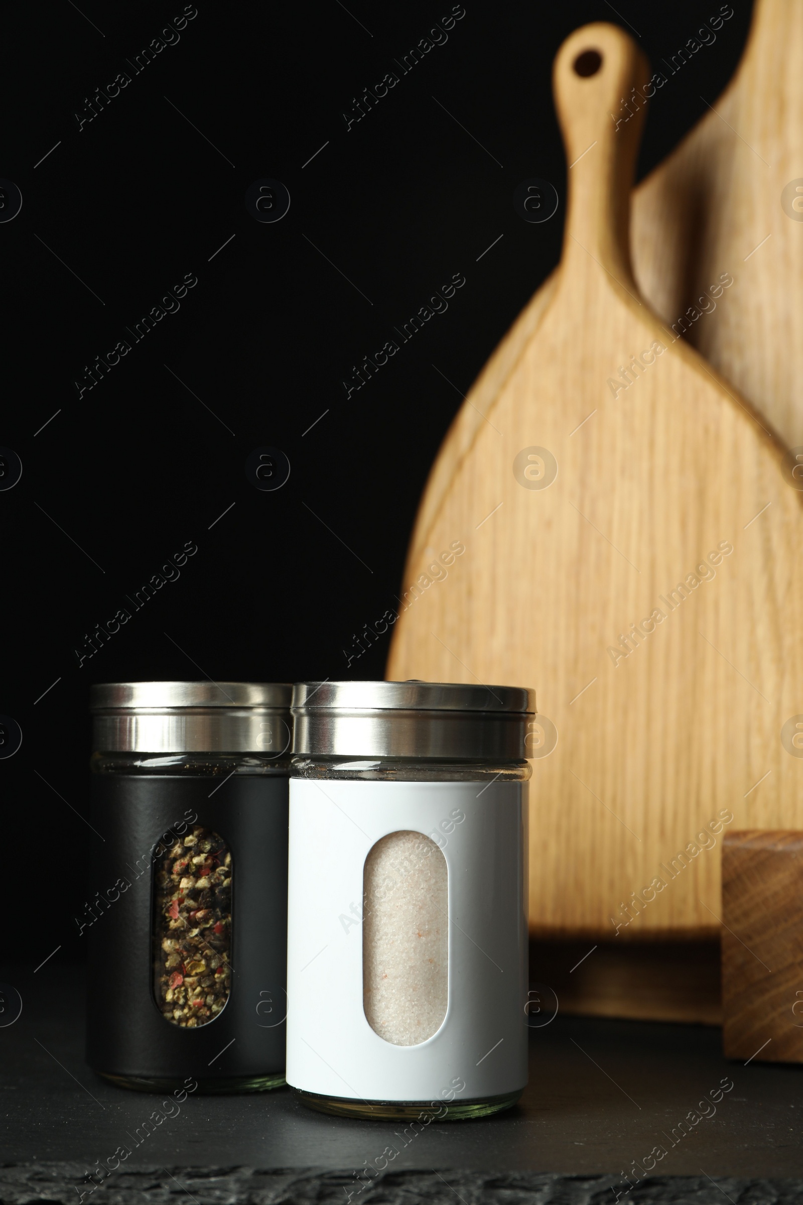 Photo of Salt and pepper shakers on black table