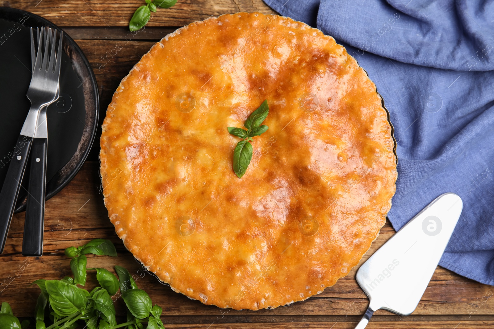 Photo of Delicious pie with meat and basil on wooden table, flat lay