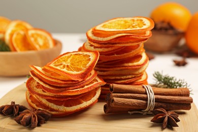 Photo of Dry orange slices, anise stars and cinnamon sticks on wooden board