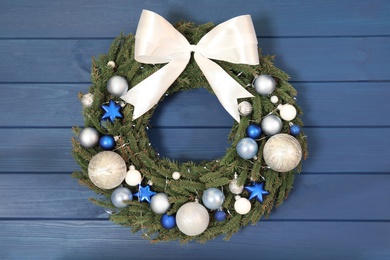Beautiful Christmas wreath on blue wooden background, top view