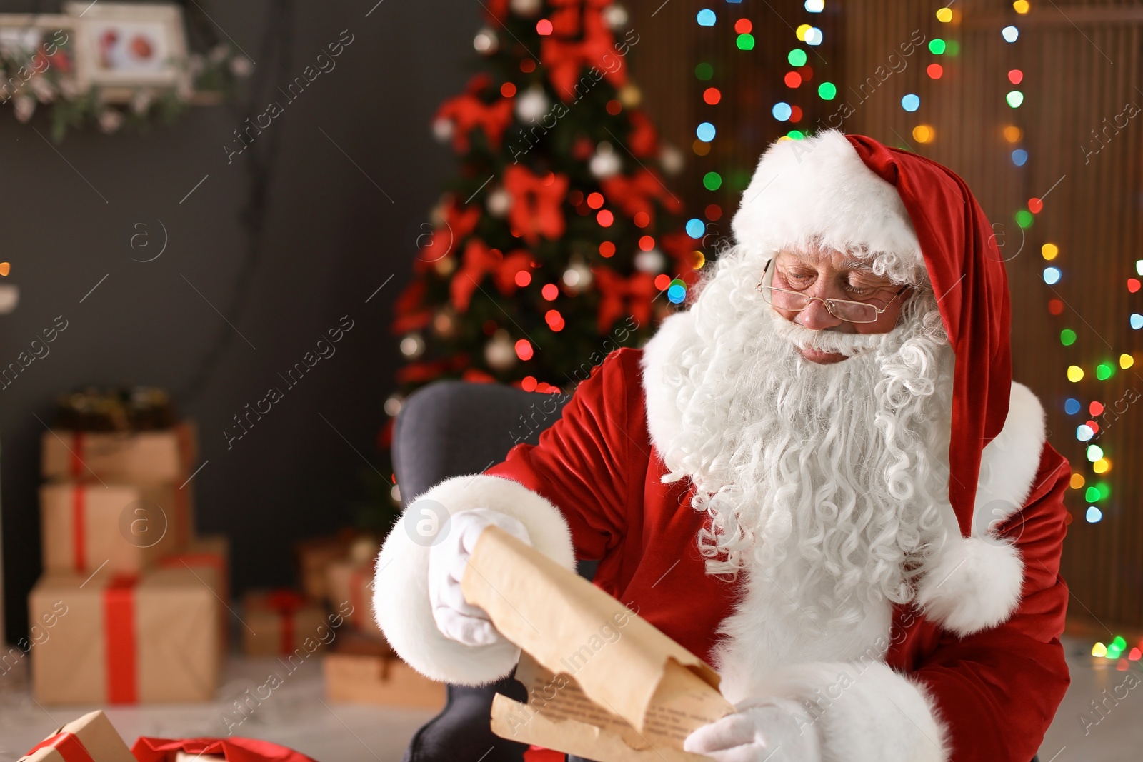 Photo of Authentic Santa Claus reading wish list indoors