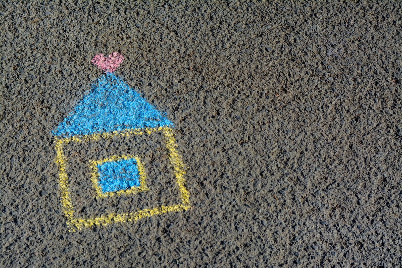 Photo of House with heart drawn by blue and yellow chalk on asphalt, space for text