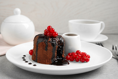 Delicious warm chocolate lava cake with berries on grey table