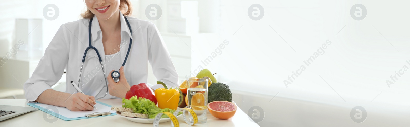 Image of Nutritionist working at desk in office, closeup view with space for text. Banner design