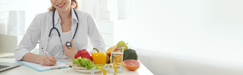 Image of Nutritionist working at desk in office, closeup view with space for text. Banner design