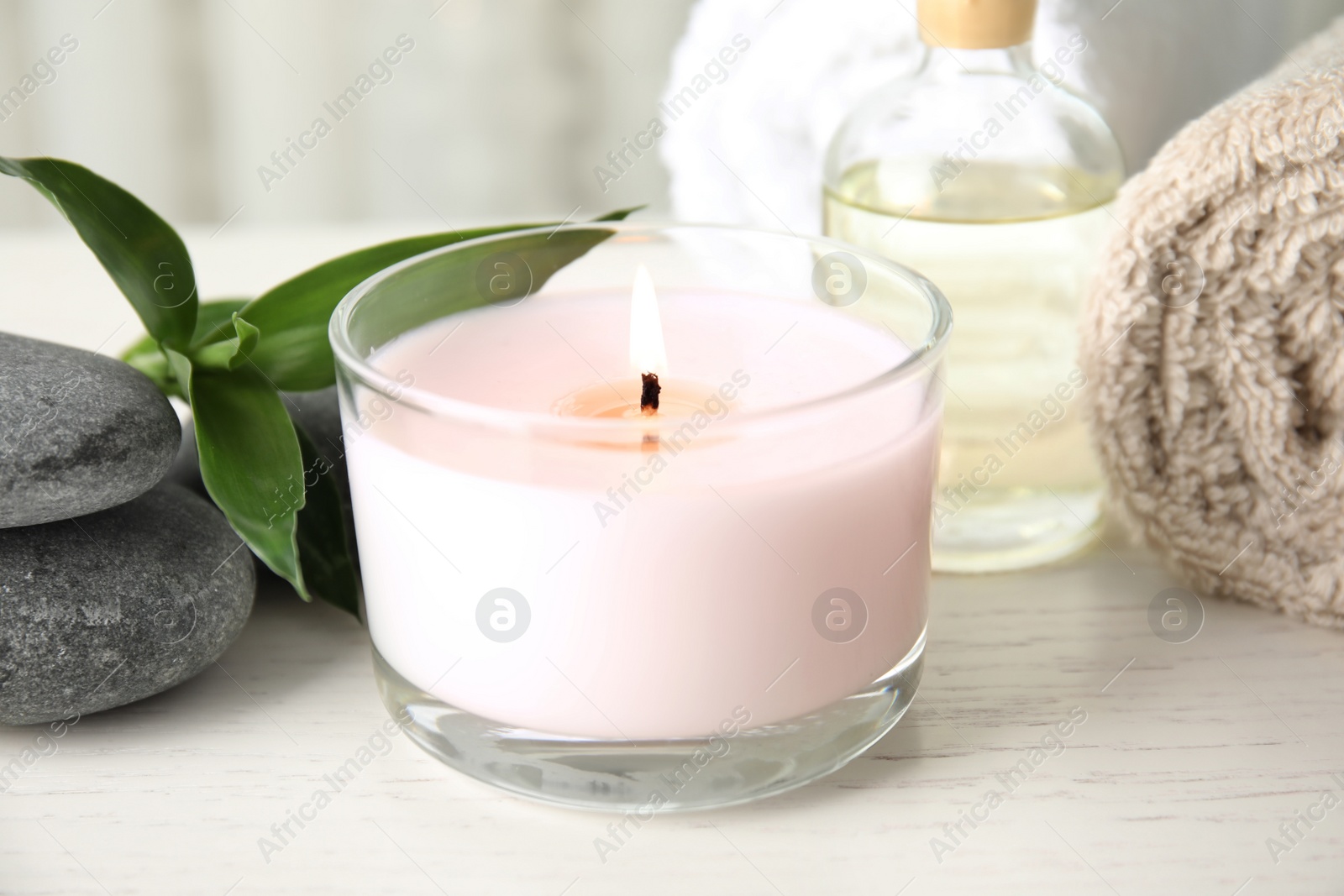 Photo of Spa composition with burning candle on table, closeup