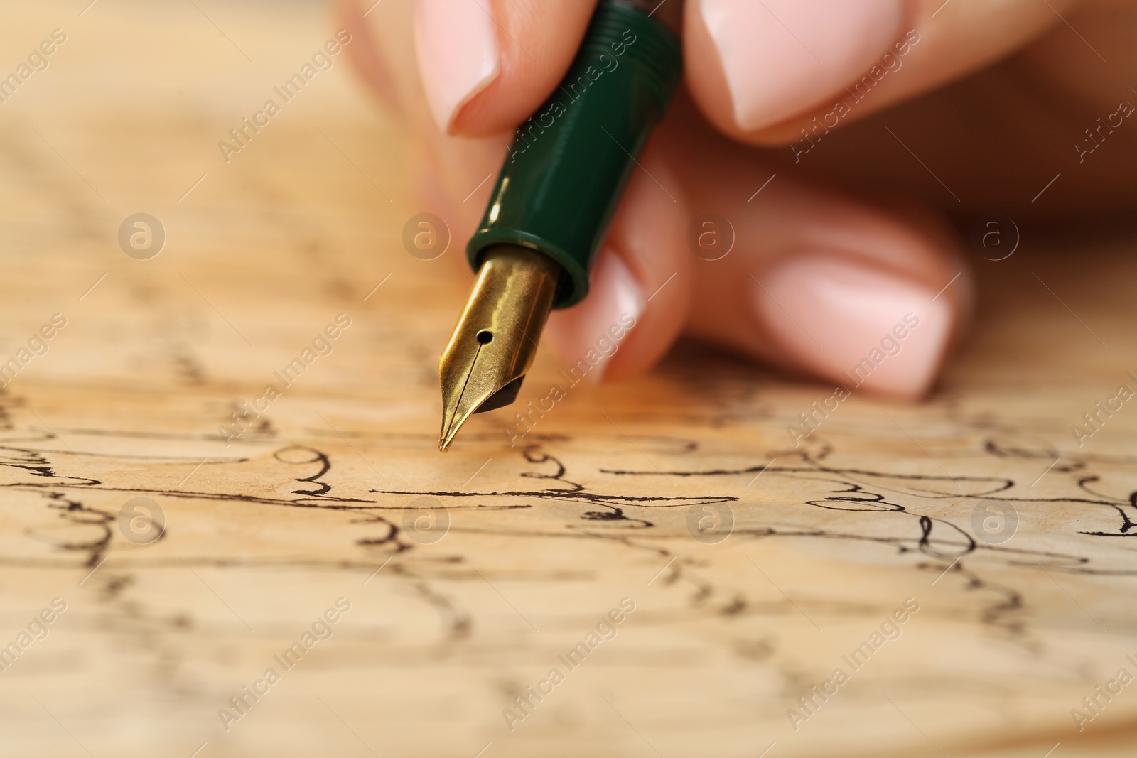 Photo of Woman writing letter with fountain pen, closeup