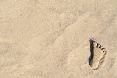 Photo of Human foot made of sand on beach, top view. Space for text