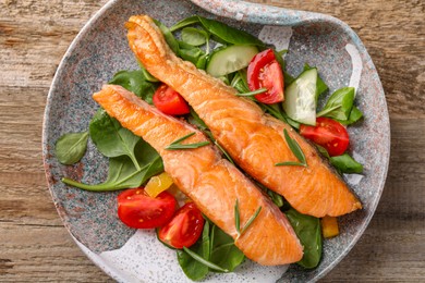 Photo of Healthy meal. Tasty grilled salmon with vegetables and spinach on wooden table, top view