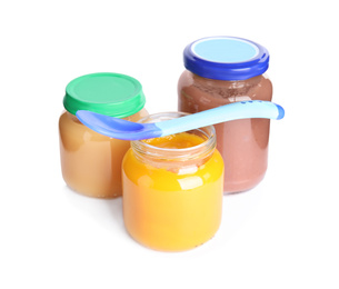 Jars with baby food and spoon on white background