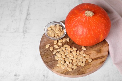 Photo of Fresh pumpkin and vegetable seeds on white table, above view. Space for text