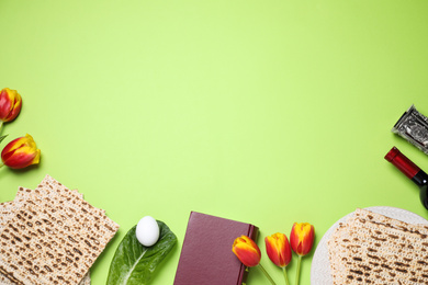 Photo of Flat lay composition with symbolic Pesach (Passover Seder) items on green background, space for text