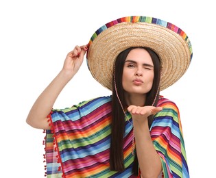 Young woman in Mexican sombrero hat and poncho blowing kiss on white background