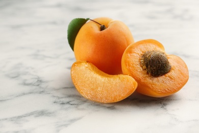 Delicious ripe sweet apricots on marble background. Space for text