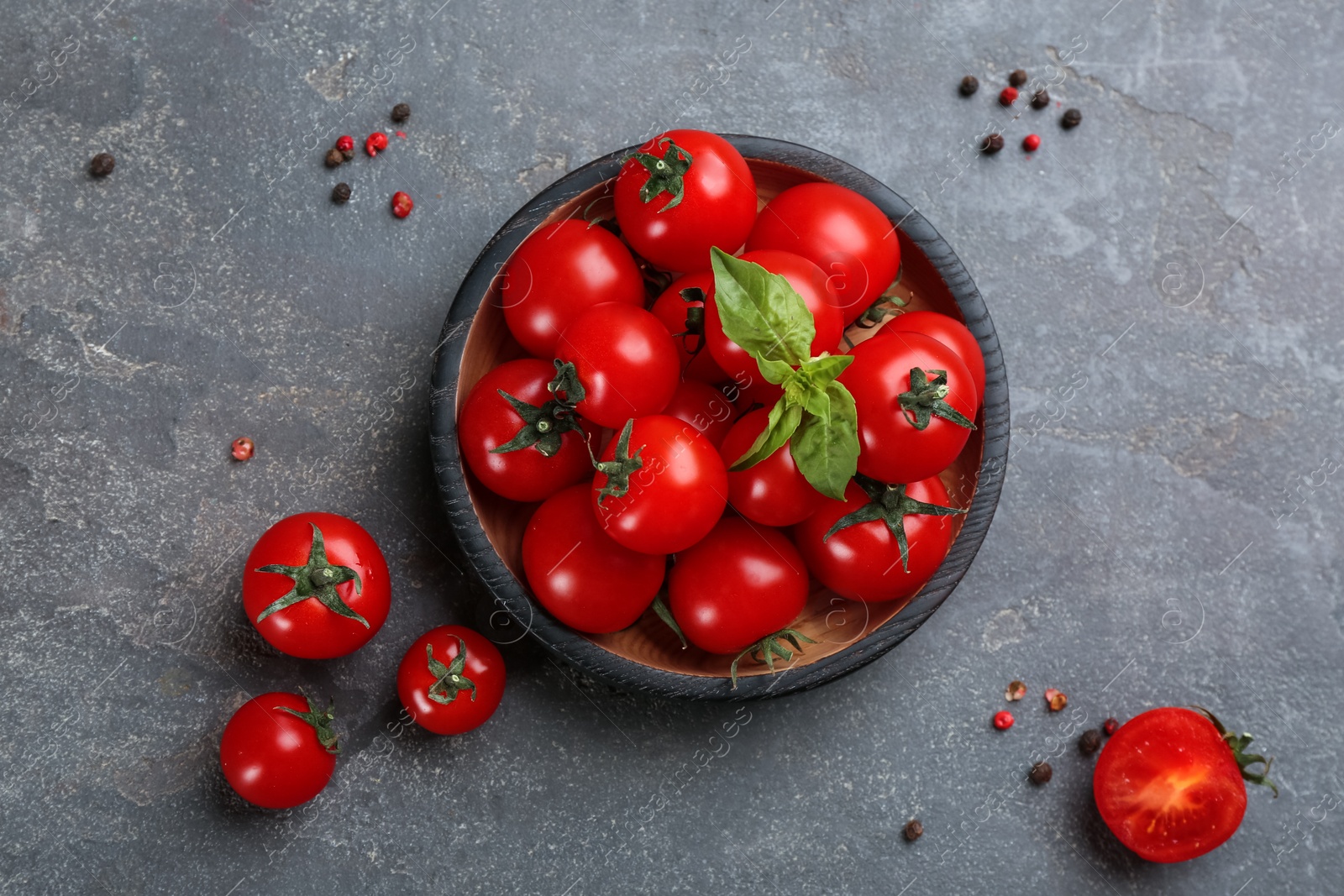 Photo of Fresh ripe cherry tomatoes, basil and peppercorns on grey table, flat lay