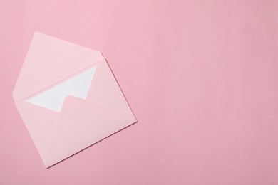 Photo of Letter envelope with card on pink background, top view. Space for text