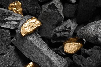 Photo of Shiny gold nuggets on coals, closeup view