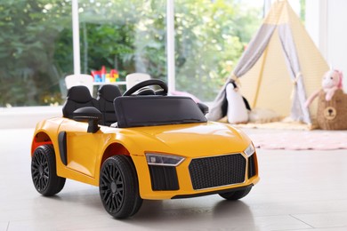 Photo of Yellow car in room at home. Child's toy