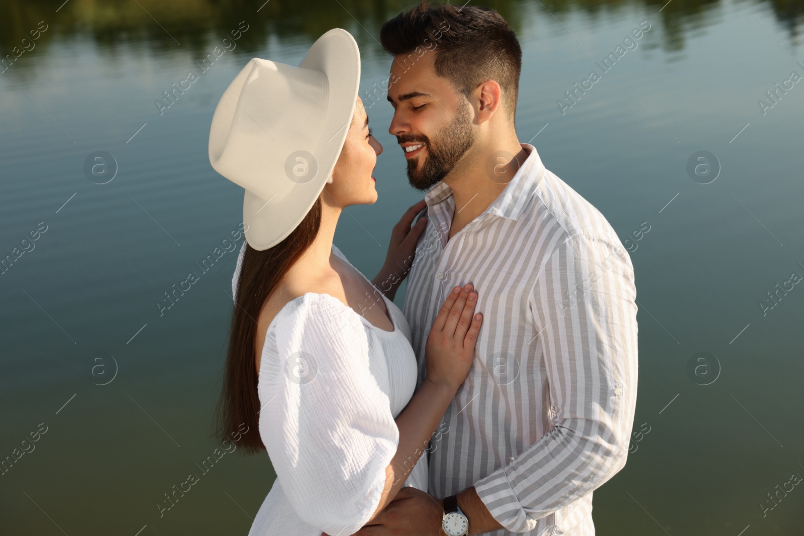 Photo of Romantic date. Beautiful couple spending time together near lake